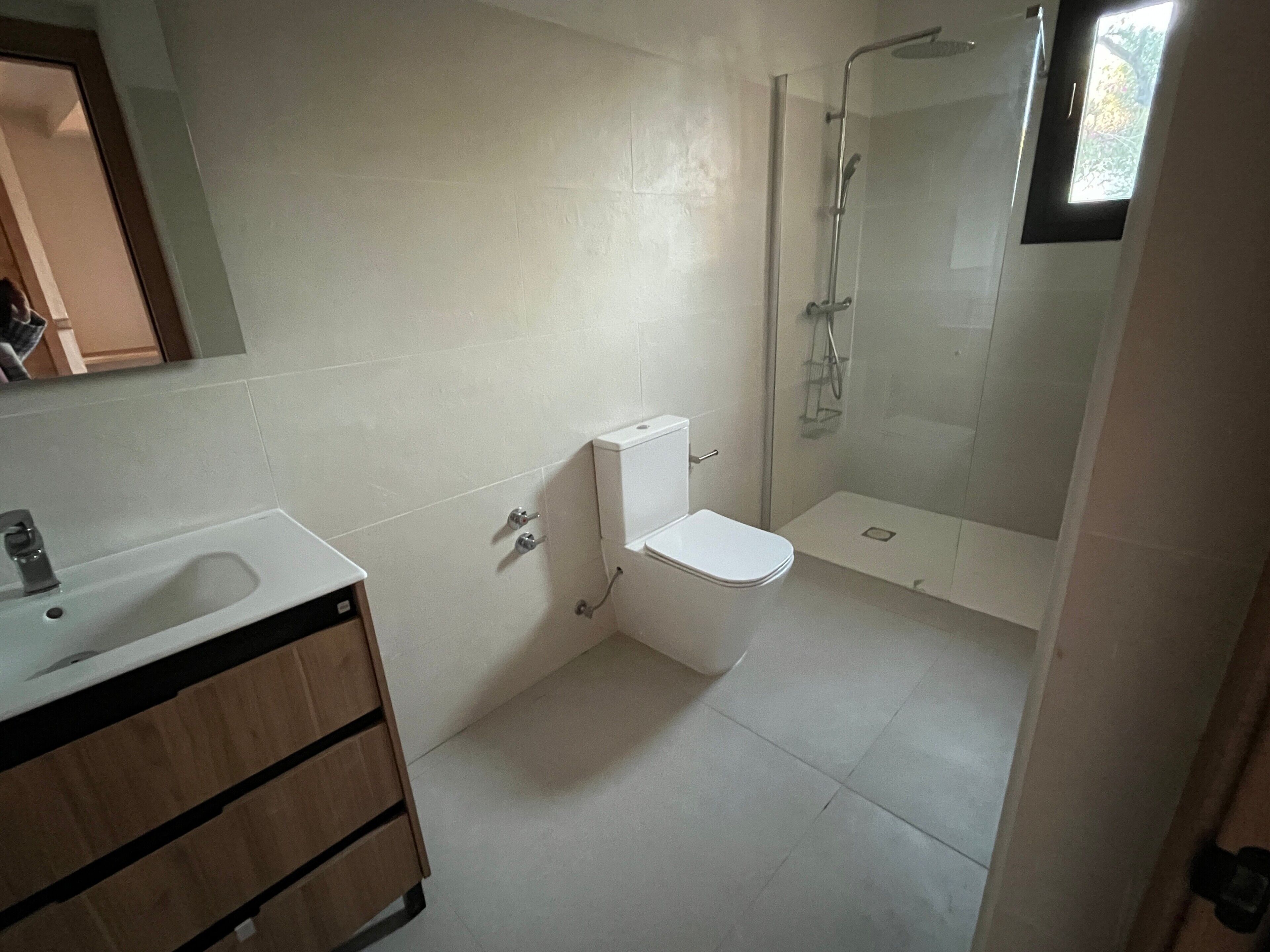 Un baño con inodoro, lavamanos y ducha.