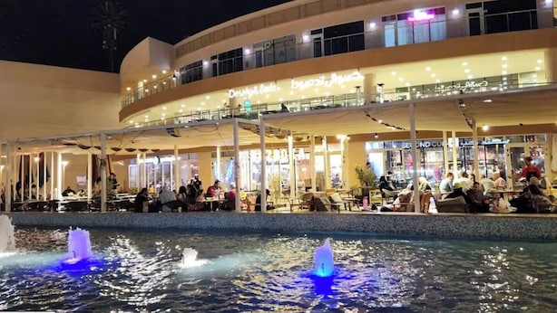 A multi-level building with outdoor seating areas and a water feature. - Host Prime Boutique hotel 25 (New Cairo)
