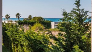 A view of a coastal area with dense greenery and a clear blue sky. - Golden Hour Balcony Apartment | Pool & Beach 100m by PikHost (Tale)