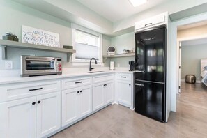 Fridge, toaster, cookware/dishes/utensils, dining tables