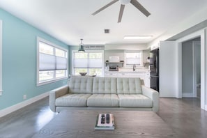 Una sala de estar moderna con un sofá, una mesa de centro y un ventilador de techo.
