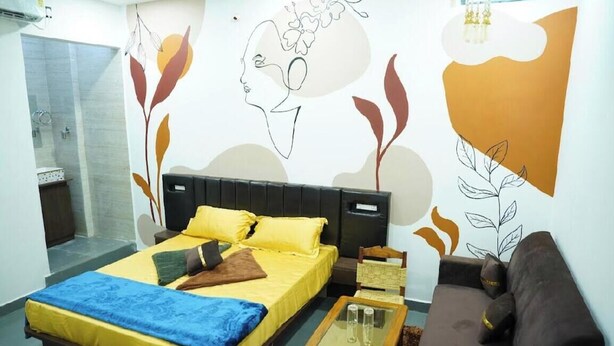Een slaapkamer met een bed, een bank, een glazen salontafel en een douche.