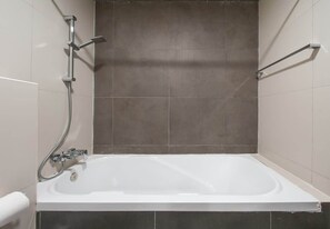 A bathroom with a bathtub, a shower, and a toilet. - Studio w/ Pool & Gym at JVC Living Garden (Dubai)