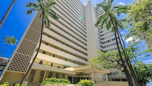 A multi-story hotel with a modern design, featuring a covered entrance and palm trees. - Oceanfront Gold Coast with Full Ocean & Diamond Head Views! Free Parking! (Honolulu)