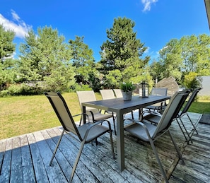 An outdoor deck with a table and chairs, surrounded by trees and a clear sky. - Family house near Darß - fireplace & terrace, quiet location, tastefully furnished. (Pruchten)