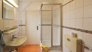 A bathroom with a sink, toilet, and shower.