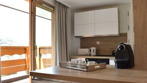 Una cucina moderna con un piano di lavoro in legno, una macchina per il caffè e un bollitore.