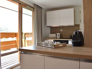 Una cocina moderna con encimera de madera, una cafetera y un hervidor.