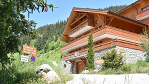Una chalet in legno con balconi, una base in pietra e cartelli che indicano parcheggio riservato al Grand Duc.