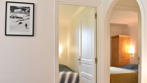 Una camera d'albergo con un letto, una sedia, una lampada e un quadro appeso al muro.