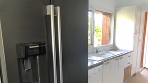 Eine Küche mit integriertem Wasserspender, einer Spüle und weißen Schränken.
