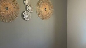 Ein Schlafzimmer mit einem Bett, einem runden Wandziertelement und einem weiteren Wandelement.
