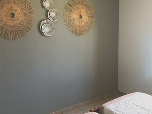 Ein Schlafzimmer mit einem Bett, einem runden Wandziertelement und einem weiteren Wandelement.