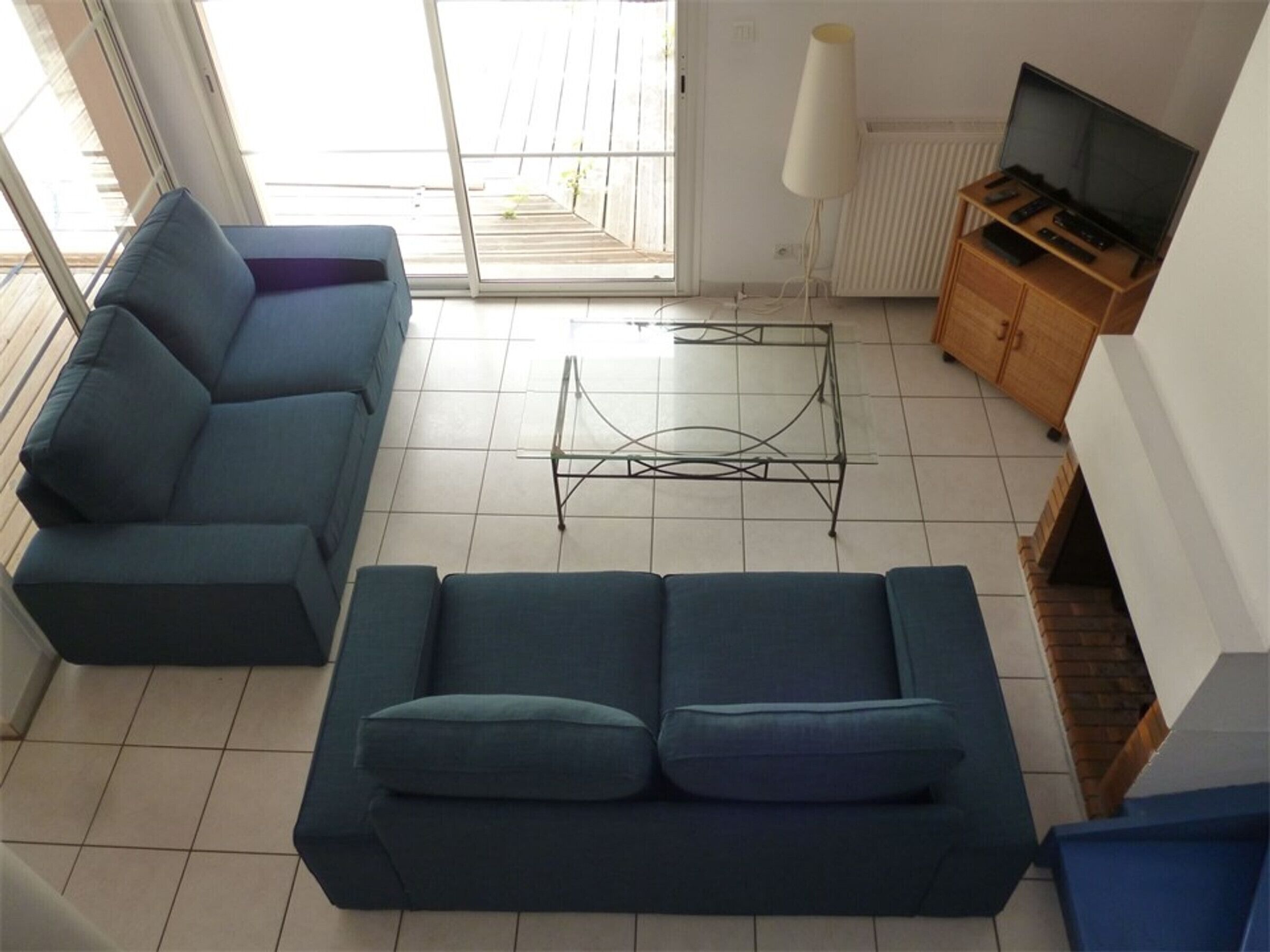 Ein Wohnzimmer mit einer Couch, einem Couchtisch, einem Fernsehschrank und einer Heizung.