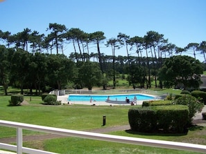 Une piscine entourée d’une pelouse bien entretenue et d’arbres.