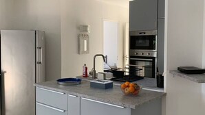 Une cuisine moderne équipée d’un réfrigérateur, d’un four et d’un évier avec un robinet.