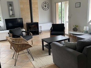 A living room with a fireplace, two sofas, a TV, and a dining area. - House with heated pool - 8 guests (Moliets-et-Maa)