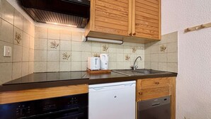 Una cucina con mobili in legno, una lavastoviglie e un lavello.