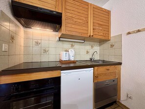A kitchen with wooden cabinets, a dishwasher, and a sink. - Spacious apartment with private garden - 6 guests (Le Monêtier-les-Bains)