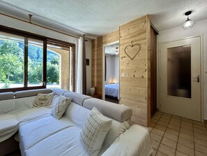 Een moderne slaapkamer met een groot raam, een houten wand met decoratie in de vorm van een hart, en een deur met een raam met patroon.
