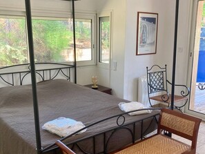 A four-poster bed with a brown bedspread, a chair with a woven backrest, and a framed picture on the wall. - Villa with private heated pool - 10 guests (Moliets-et-Maa)