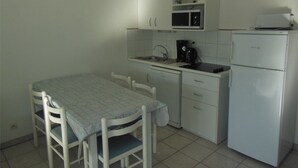 A small kitchenette with a table, chairs, a microwave, a coffee maker, and a refrigerator. - Comfortable apartment with parking - 8/10 guests (Moliets-et-Maa)