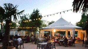 An outdoor dining area with tables and chairs, a white tent, and string lights. - Cozy chalet, pets welcome - 6 guests (Villegly)
