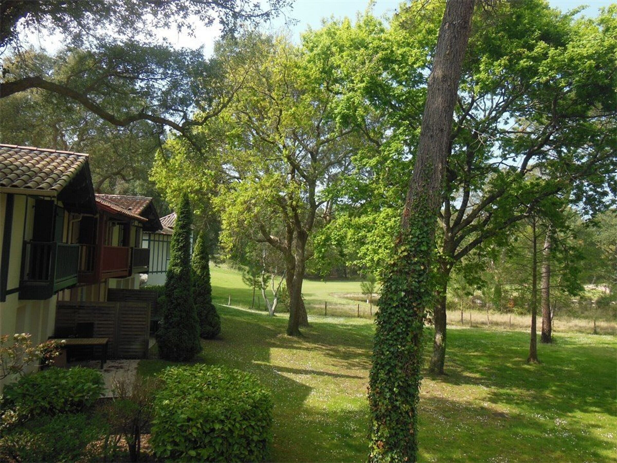 Ett traditionellt hus med ett tegeltak, omgivet av frodig grönska och träd.
