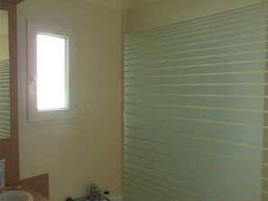 A bathroom with a window, a sink, and a shower with horizontal blinds. - Charming apartment with pool - 6 guests (Moliets-et-Maa)