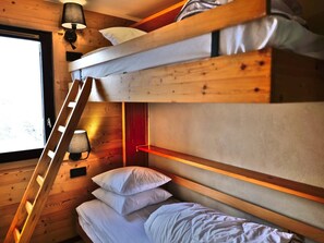 A bunk bed with a ladder, a bedside table, and a wall-mounted lamp. - Convenient studio, ski-in/ski-out - 4 guests (Le Grand-Bornand)