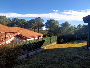 A residential property with a tiled roof, a fenced yard, and a hedge. - Charming cottage in Moliets - 4 guests (Moliets-et-Maa)