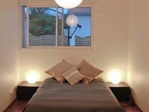 A bedroom with a bed, two bedside lamps, and a window with a view of the outside. - Villa with heated pool - 8 guests (Moliets-et-Maa)
