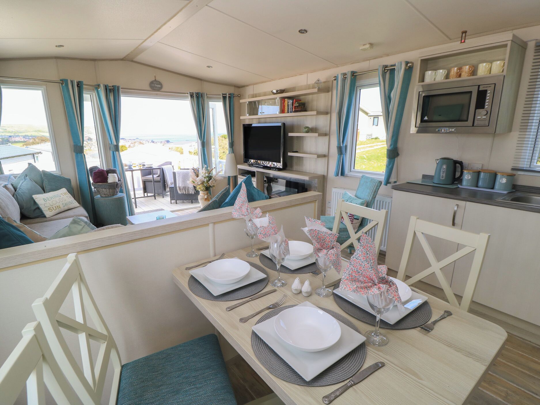 Un interior acogedor con zona de comedor, televisor y cocina.