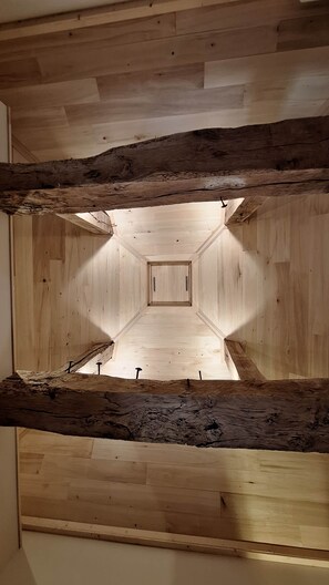 A room with a wooden ceiling, a central light fixture, and a symmetrical design. - Gîte le pigeonnier de la jalberterie (Varen)