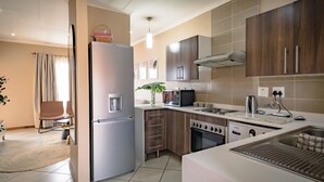 A modern kitchen with a refrigerator, microwave, stove, and sink.