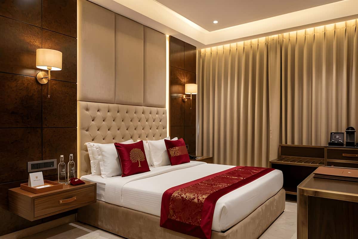 Una habitación de hotel moderna con una cama grande, una mesita de noche, un escritorio y un ventanal con cortinas.