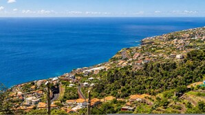 Uma vila costeira com vista para o mar, estradas sinuosas e edifícios residenciais.