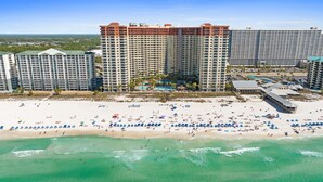 Ein Strandhotel mit mehreren Hochhäusern, einem Sandstrand und einem Poolbereich.