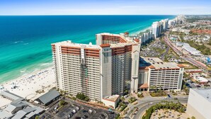 Ein Hochhaus-Hotel mit mehreren Etagen, Blick auf den Strand und einem Parkplatz.