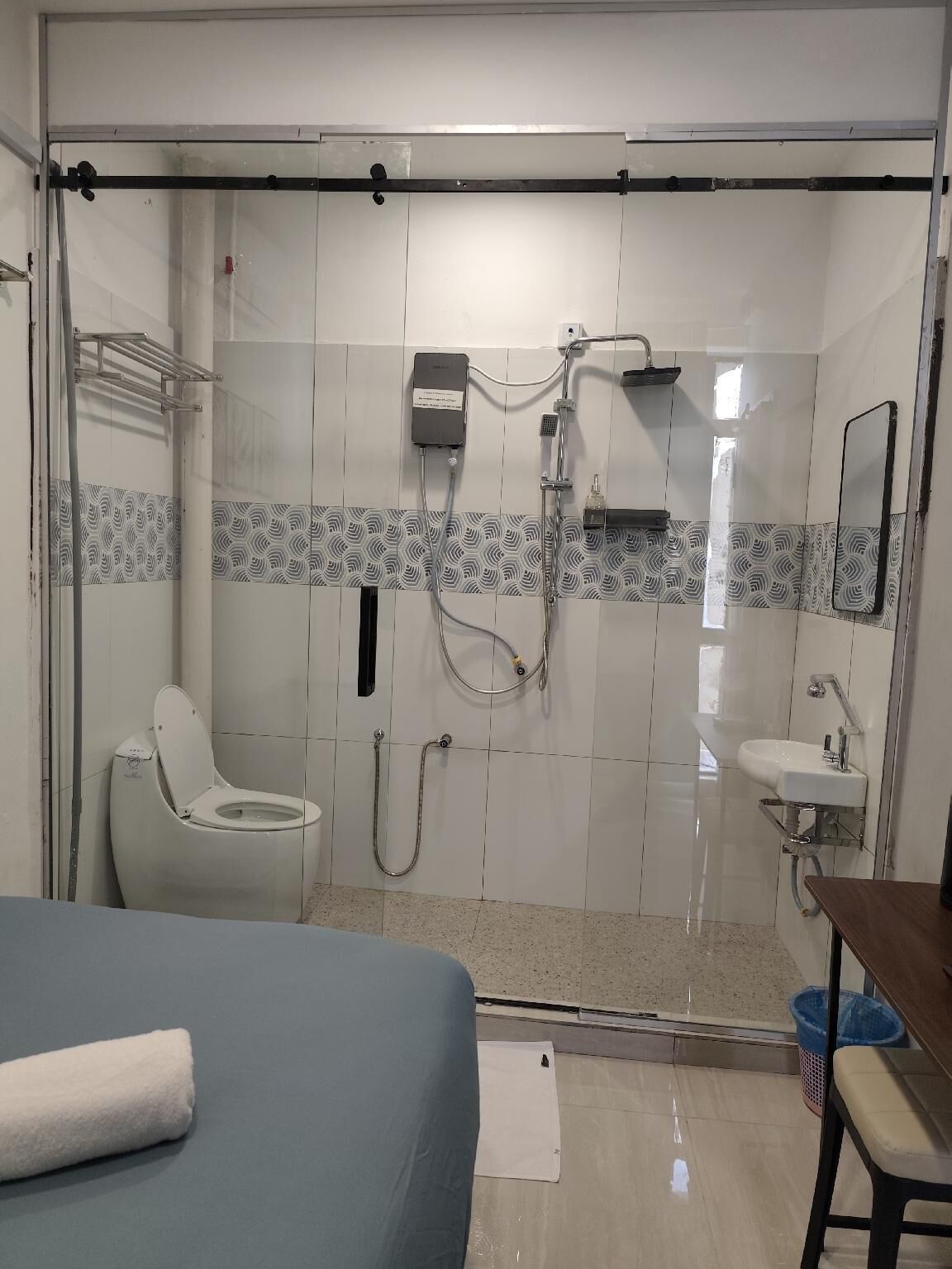 Et badeværelse med toilet, bruser og håndvask.