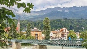 A bridge over a river with buildings and a church in the background. - A little dream in the heart of Innsbruck: Stylish apartment near the old town (Innsbruck)
