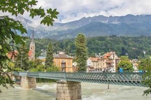 Eine Brücke über einem Fluss, im Hintergrund Gebäude und eine Kirche.