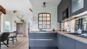 A modern kitchen with a central island, built-in appliances, and a large window. - Apartment "Hof Wuushöh" with Shared Garden, Balcony, and Wi-Fi (Stolk)