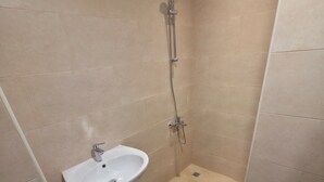 Ein kleines Badezimmer mit Dusche, Waschbecken und Toilette.