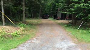 A gravel path leading to a cabin with a red chair outside. - 3-bedroom cabin in charming Indian Lake (Indian Lake)