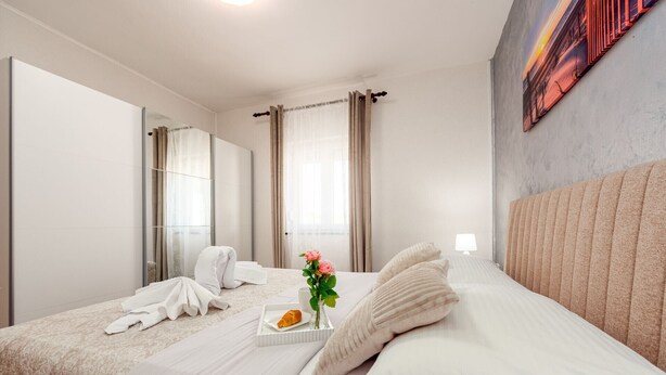 A hotel room with a bed, a mirror, a window with curtains, and a painting on the wall. - Villa Ariane with pool (Policnik)