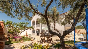 A courtyard with a dining table, chairs, and a pool area. - Villa Ariane with pool (Policnik)