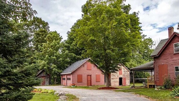 A rustic red barn with a dirt driveway and surrounding greenery. - Cape Rosier Cozy Guesthouse (Harborside)