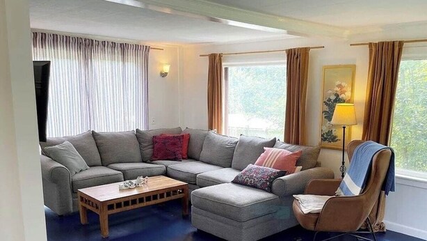 Una sala de estar con un sofá modular, una mesa de centro de madera y un sillón.