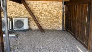 An attic space with a sloped ceiling, exposed wooden beams, and a stone wall. - Les cabanes (Noaillan)